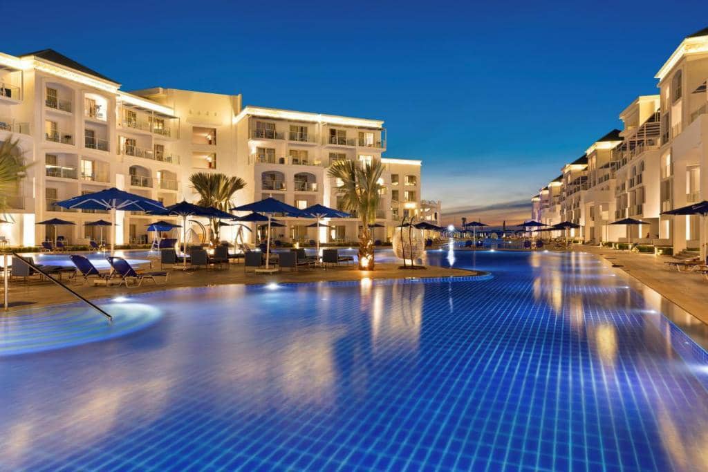 Blu Spa Resort lagoon pools and buildings at night.