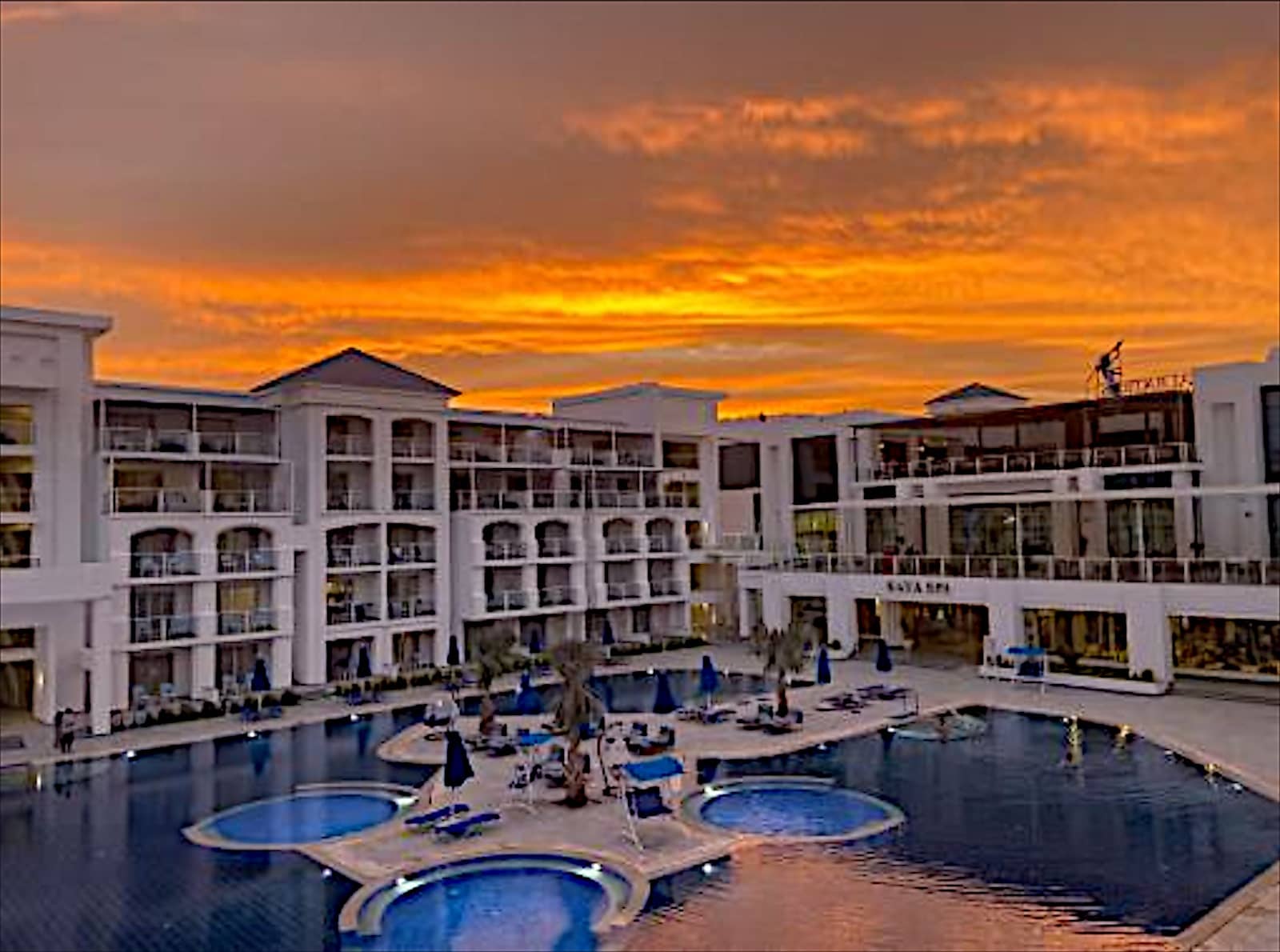 Blu Spa Resort buildings and pools at sunset.