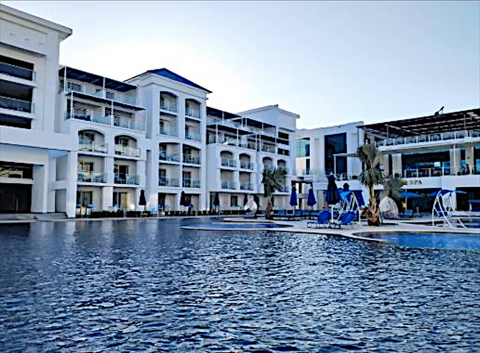 White hotel blocks facing the lagoon pool at Blu Spa Resort.